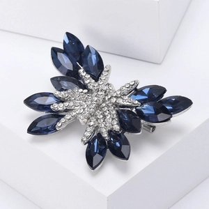 Dettaglio della spilla a farfalla in cristallo blu navy con strass bianchi scintillanti