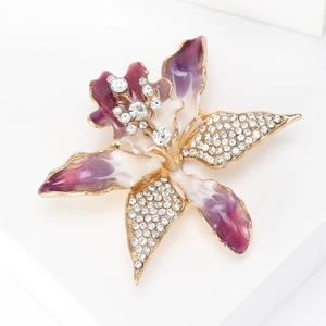 Close-up of orchid brooch featuring purple gradient enamel and sparkling white rhinestones