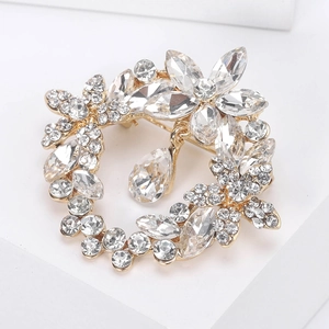 Close-up of golden crystal wreath brooch featuring sparkling marquise and teardrop stones