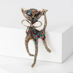 Detailed close-up of a vintage cat brooch with multi-colored rhinestones on gold alloy