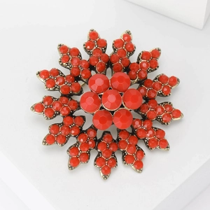 Detail of a Baroque brooch featuring red faceted beads on a vintage gold base