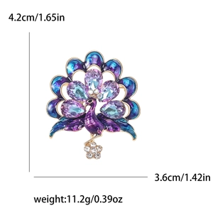 Elegant peacock brooch with blue and purple rhinestones on a gold-plated metal base