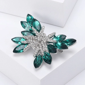 Dettaglio dei cristalli marquise smeraldo e diamanti su una spilla a farfalla argentata