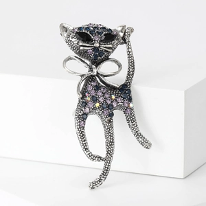 Detailed view of vintage silver cat brooch with blue and purple crystal embellishments