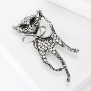 Close-up of cat brooch with silver-tone metal base and white rhinestones and black gem eyes