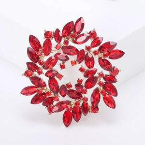 Detailed macro view of a gold-plated brooch set with red marquise-cut crystals