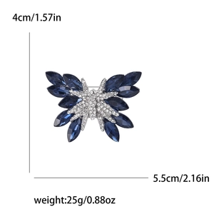 Elegante spilla a farfalla con cristalli blu e strass bianchi su uno sfondo bianco puro