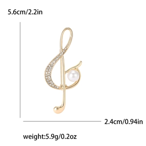 Elegante spilla a forma di nota musicale dorata con cristalli e perla su fondo bianco