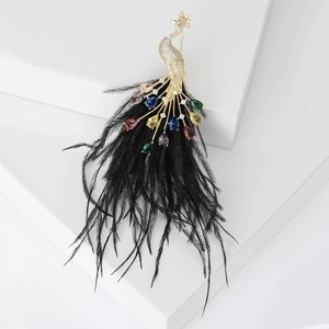 Vintage gold peacock brooch with colorful crystals and long black feather accents