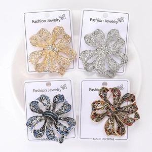 Vue détaillée de quatre broches florales en cristal au design ajouré sur plateau blanc