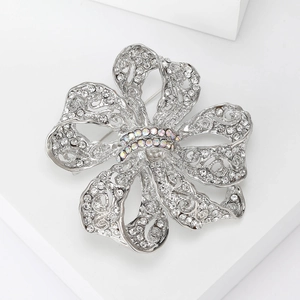 Détail macro d'une broche fleur argentée avec cristaux blancs et pierres nacrées