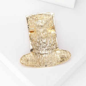Elegant gold metal top hat brooch featuring detailed textured finish and secure pin back