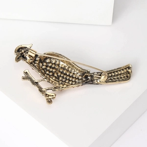 Spilla a forma di uccello in oro vintage con strass rossi e finitura antica su base