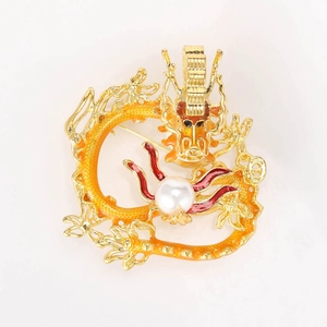 Detailed macro view of the colorful enamel dragon brooch holding a white pearl centerpiece