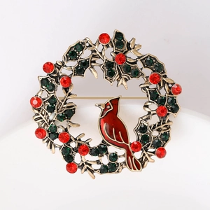 Detail of Christmas wreath brooch with a red bird and inlaid rhinestones on vintage gold