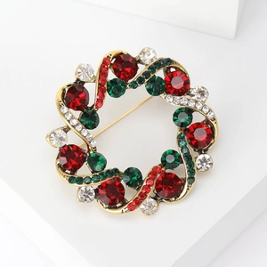 Détail de la broche couronne de Noël dorée sertie de strass multicolores
