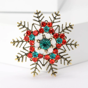 Macro shot of snowflake brooch with gold metal and multicolor rhinestone inlay