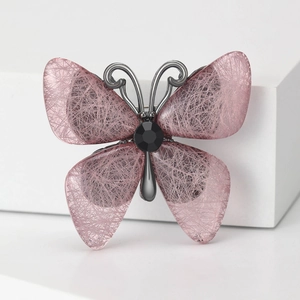 Schmetterling-Brosche mit rosa Flügeln und schwarzem Stein auf weißem Hintergrund