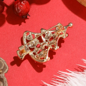 Vue arrière détaillée d'une broche sapin de Noël dorée avec motifs ajourés complexes