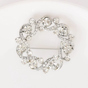 Détail de la broche couronne en argent avec cristaux scintillants et strass variés