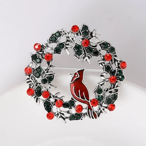 Macro detail of Christmas wreath brooch with a red cardinal bird and sparkling crystals