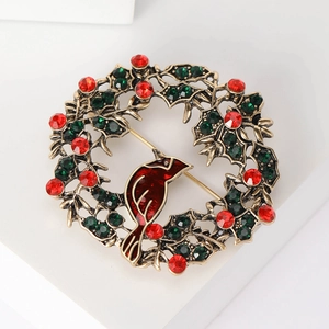 Detail of Christmas wreath brooch with red enamel bird and crystal berries in gold finish