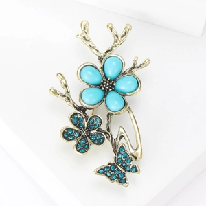 Detailed view of vintage butterfly and flower brooch with turquoise and blue rhinestones