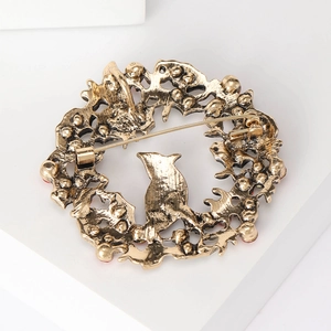 Vintage gold alloy Christmas wreath brooch with bird silhouette and red bead accents