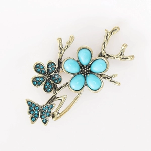 Detail of vintage gold butterfly floral brooch with blue stones and crystals