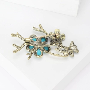 Elegant vintage butterfly and branch brooch in antique gold with turquoise stone