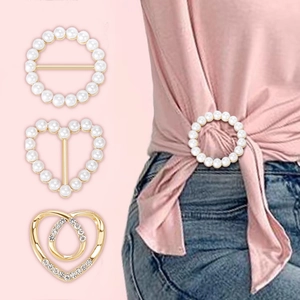 Close-up of three pearl and crystal brooch pins used for styling a pink silk scarf