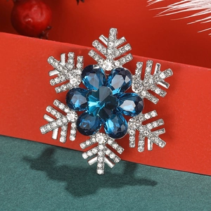Makroaufnahme der Schneeflocken-Brosche mit blauen Edelsteinen und silbernen Strasssteinen