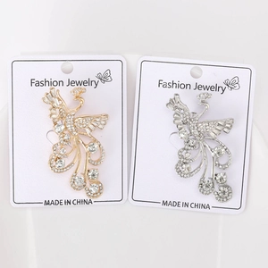 Detail view of gold and silver peacock brooches with sparkling rhinestone inlay details
