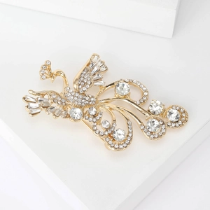 Detail of golden peacock brooch with white rhinestones and intricate metalwork