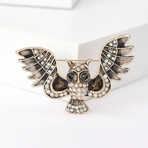 Detailed close-up of an owl brooch with golden alloy wings and colorful rhinestones