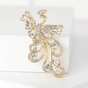 Luxurious gold-plated phoenix brooch with sparkling crystals on a white pedestal