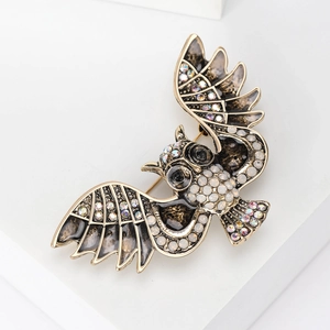 Detailed close-up of fashion owl brooch with sparkling rhinestones and enamel finish