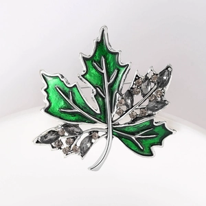 Vue détaillée de la broche feuille d'érable en émail vert et strass brillants
