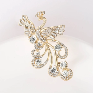 Macro detail of luxury phoenix brooch featuring shimmering crystals and golden plating