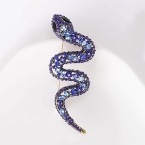 Macro detail of snake brooch with sparkling blue rhinestones on a gold alloy base