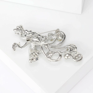 Macro detail of the silver dragon brooch back showing the pin clasp and scale texture
