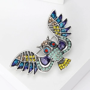 Macro detail of owl brooch showing colorful rhinestones and vintage enamel texture