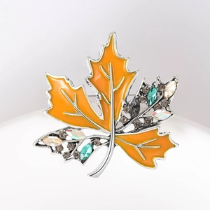 Détails de la broche en forme de feuille d'érable avec émail orange et strass colorés