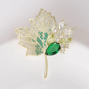 Detail shot of maple leaf brooch with green zircon teardrop and sparkling crystals