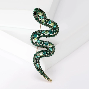 Elegant S-shaped snake brooch with emerald green rhinestones on a minimalist base