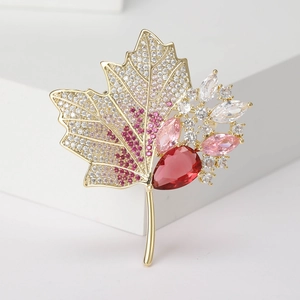 Exquisite maple leaf brooch with zircon and gemstones on a minimalist white platform