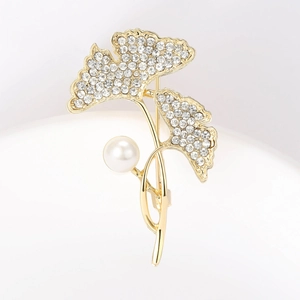 Gedetailleerde ginkgo blad broche in goud met fonkelende kristallen en witte parel