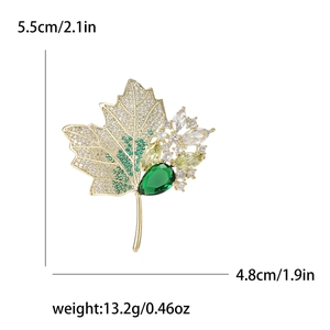Exquisite maple leaf brooch with inlaid white crystals and green stones on gold base