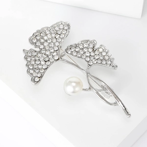 Detail van de zilveren ginkgo blad broche met fonkelende kristallen en een witte parel