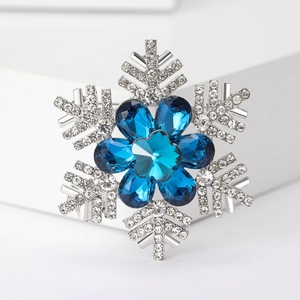 Macro shot of silver snowflake brooch with blue crystals and transparent rhinestones